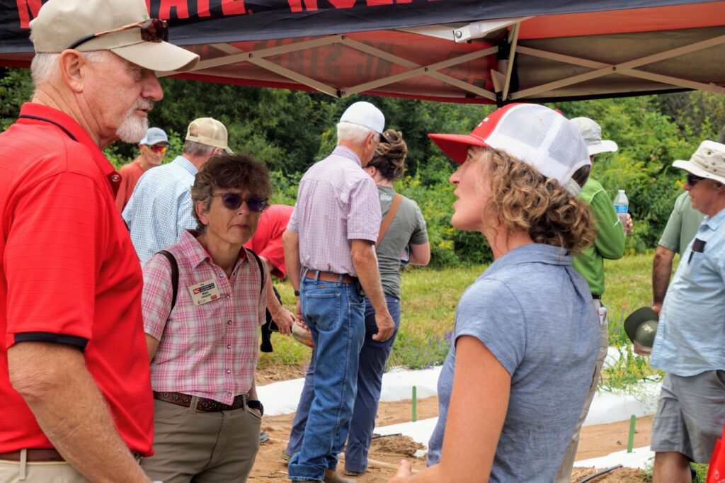 Researcher talking to field day attendees in hemp plot